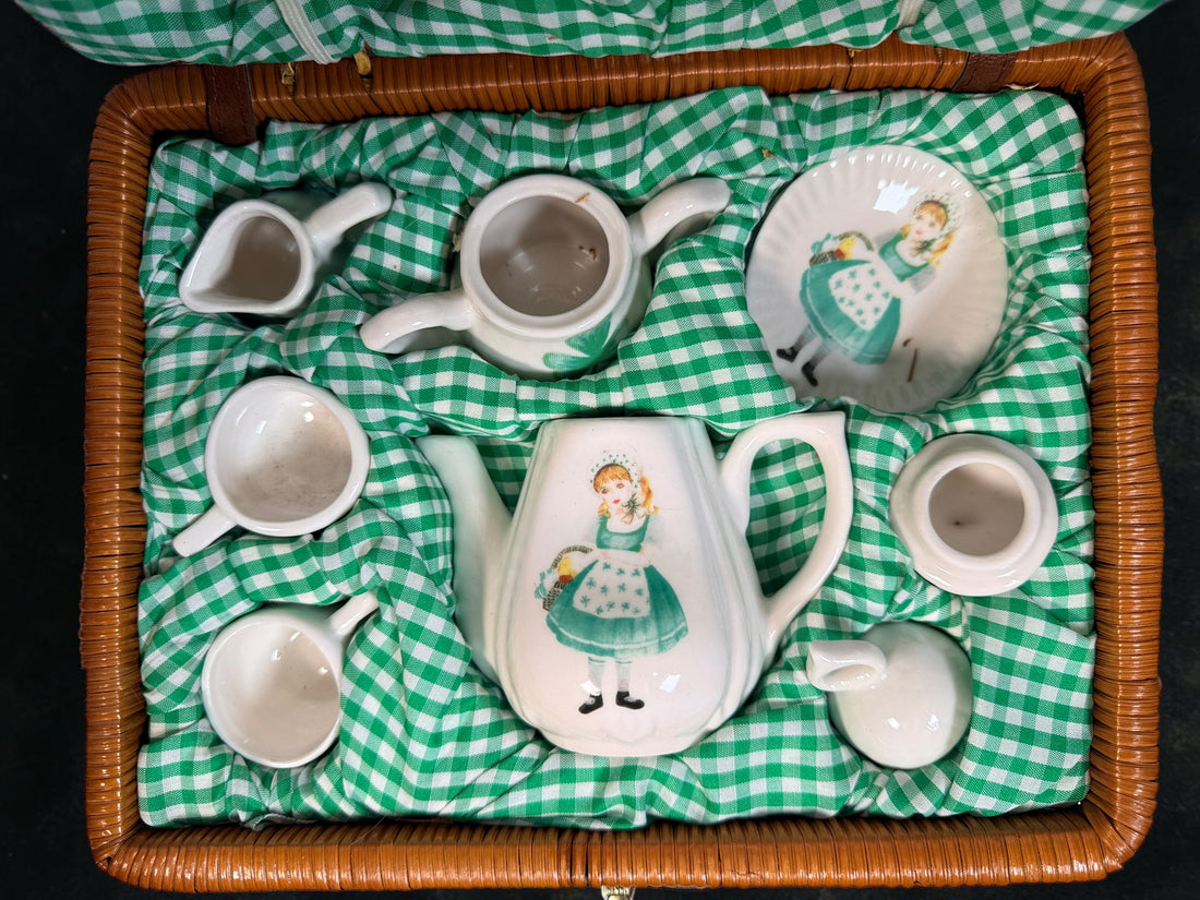 Vintage Delton miniature ceramic tea set with Irish girl and shamrock designs, complete with green gingham-lined wicker picnic basket.