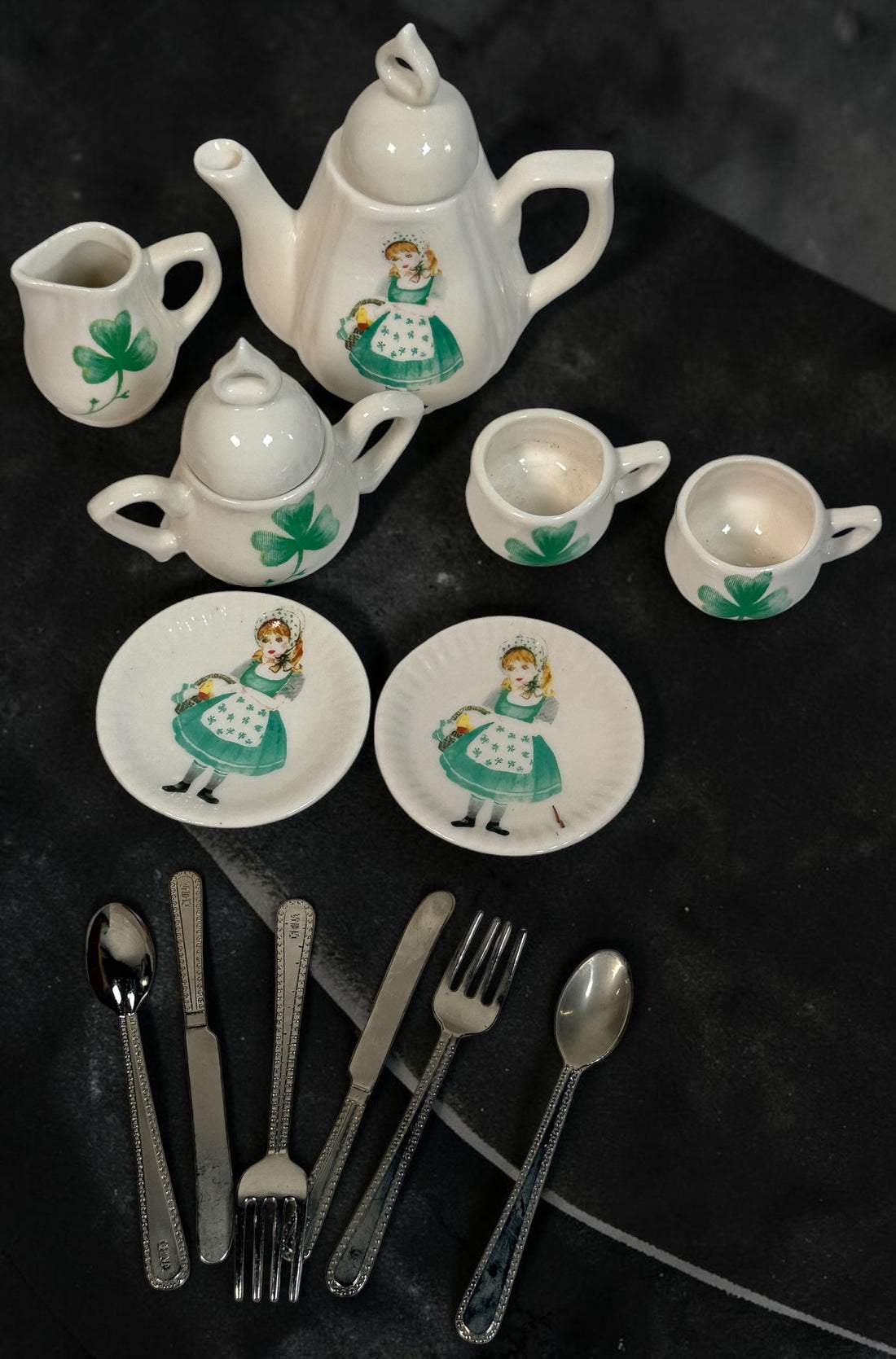 Vintage Delton miniature ceramic tea set with Irish girl and shamrock designs, complete with green gingham-lined wicker picnic basket.