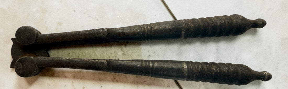 Antique Victorian reversible double nutcracker in iron with decorative handles and textured jaws. Collectible 19th-century kitchen tool.