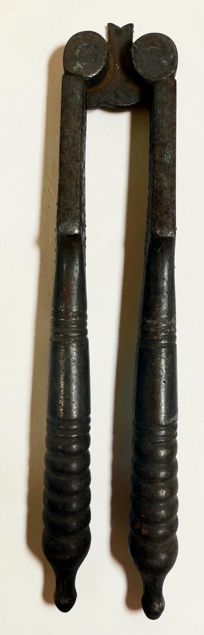 Antique Victorian reversible double nutcracker in iron with decorative handles and textured jaws. Collectible 19th-century kitchen tool.