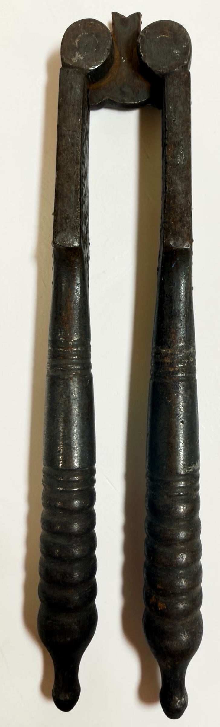 Antique Victorian reversible double nutcracker in iron with decorative handles and textured jaws. Collectible 19th-century kitchen tool.