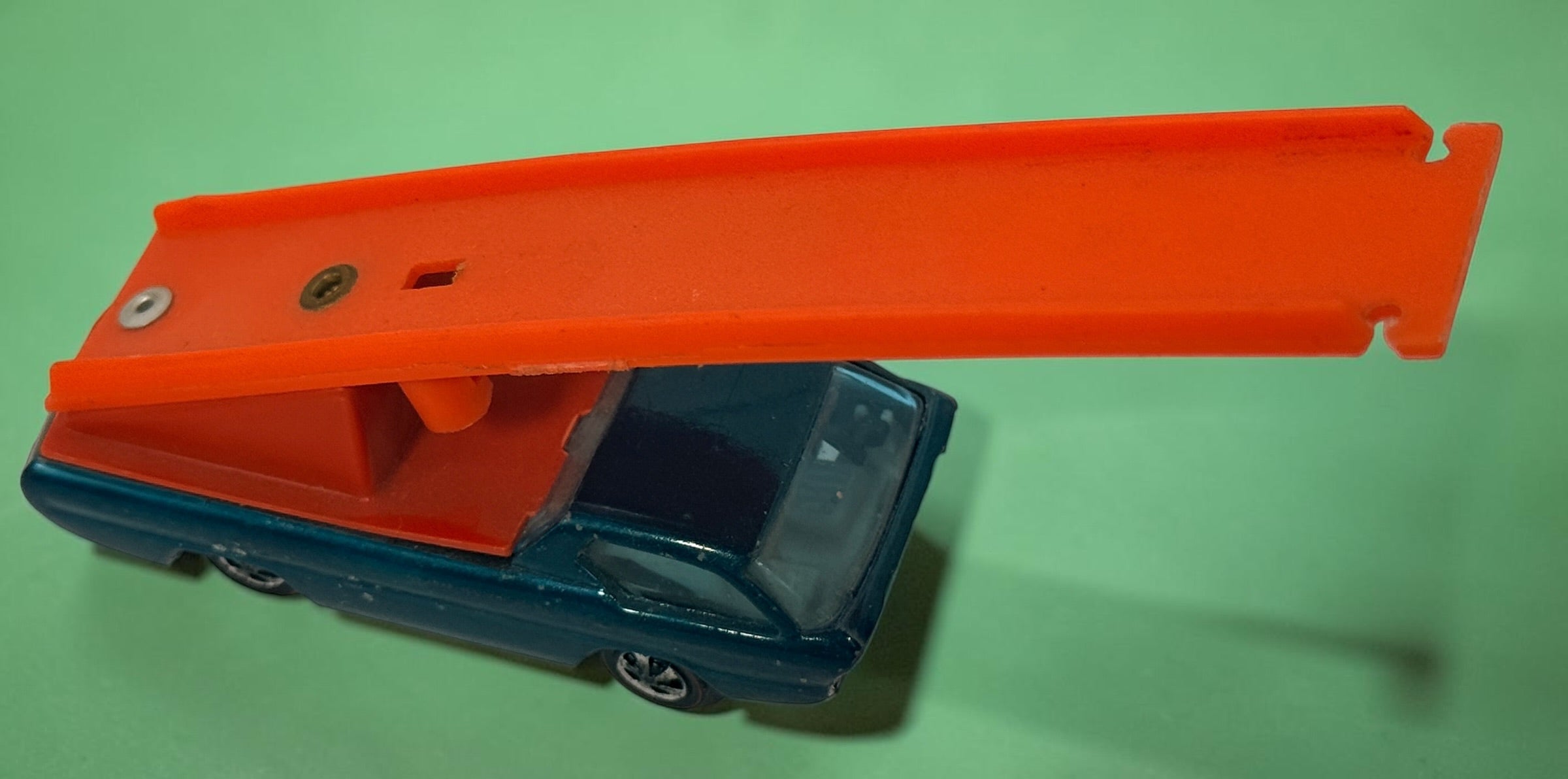 Vintage Hot Wheels Sky Show Deora with orange launcher, metallic blue-green finish and Hong Kong base. Redline-era Mattel collectible; airplane missing.