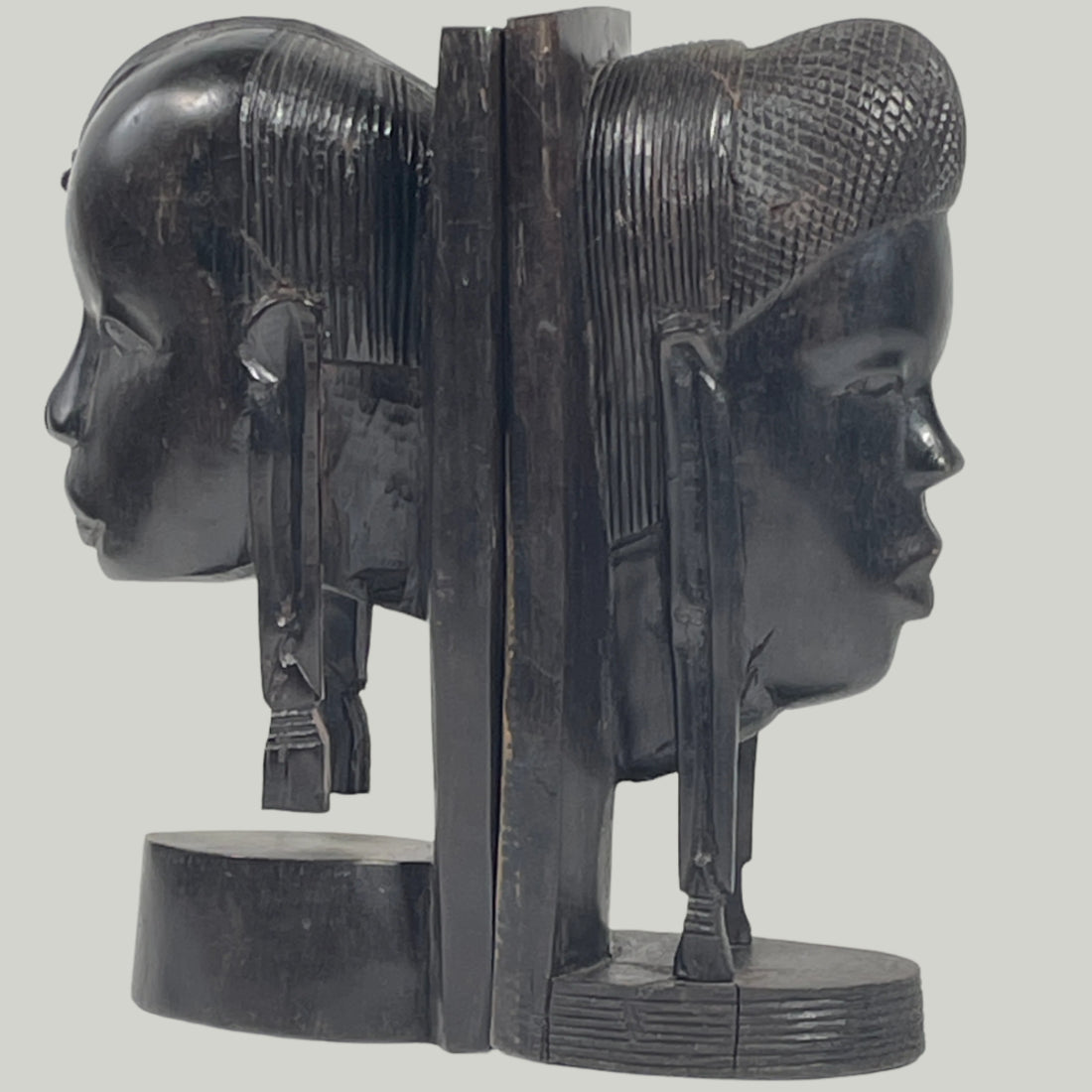 Black stone sculpture of a reclining figure with intricate details on a white background