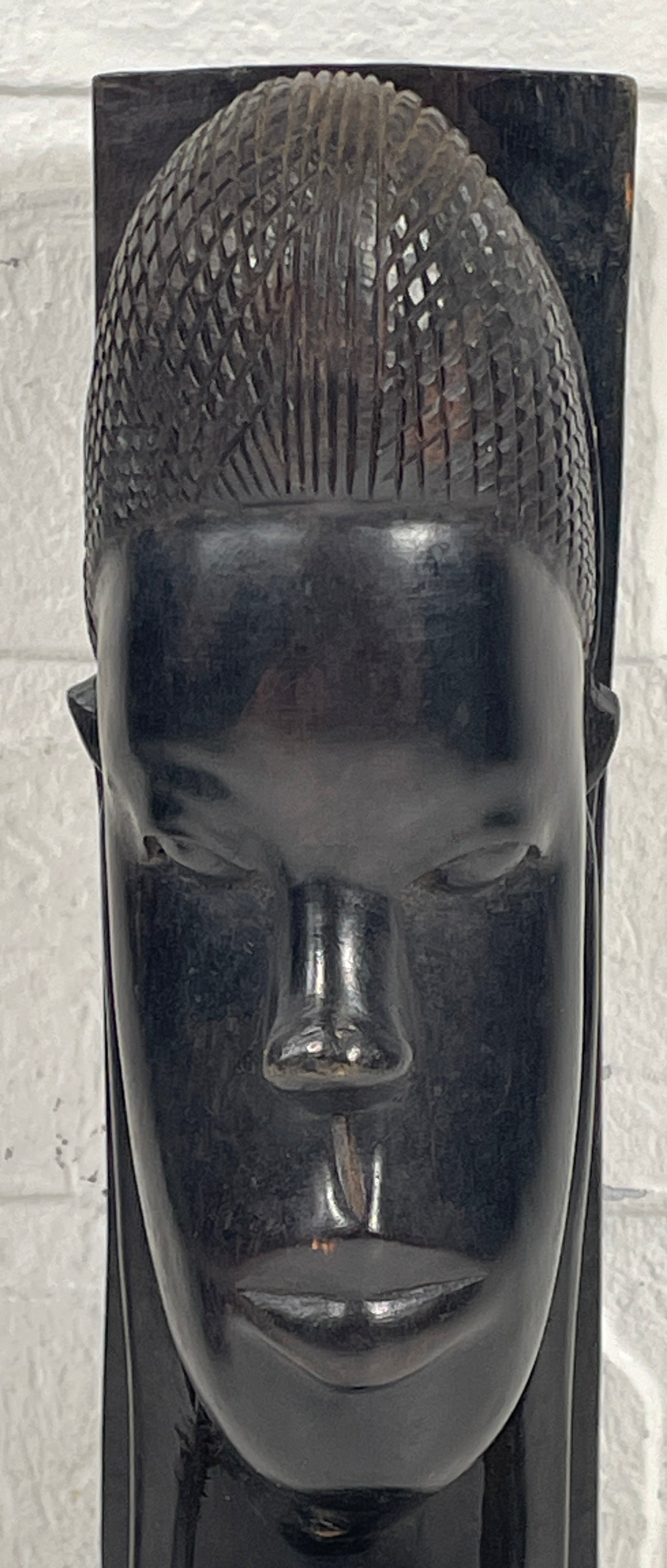 Carved stone head on a textured white background