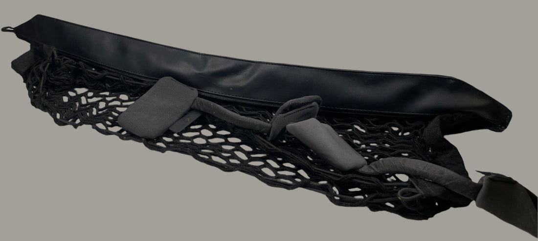 Black mesh cargo net on a white surface with a white brick wall background