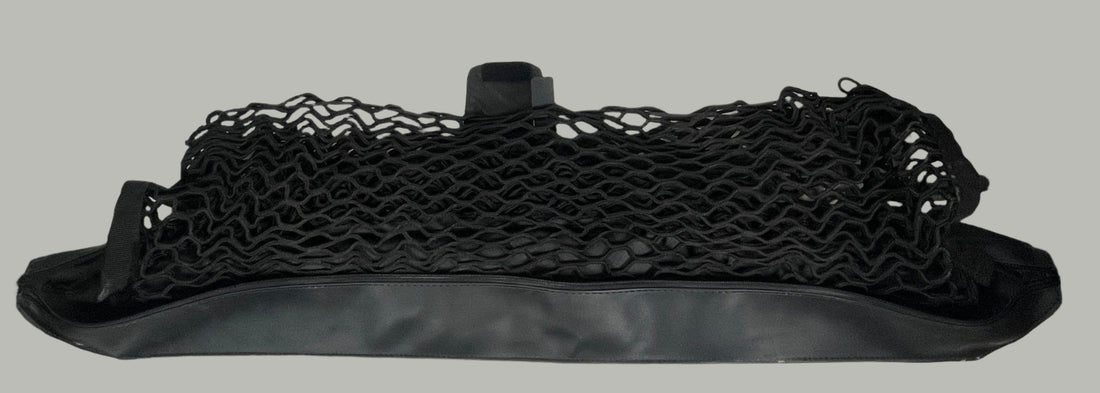 Black mesh bag on a white surface with a white tiled wall background