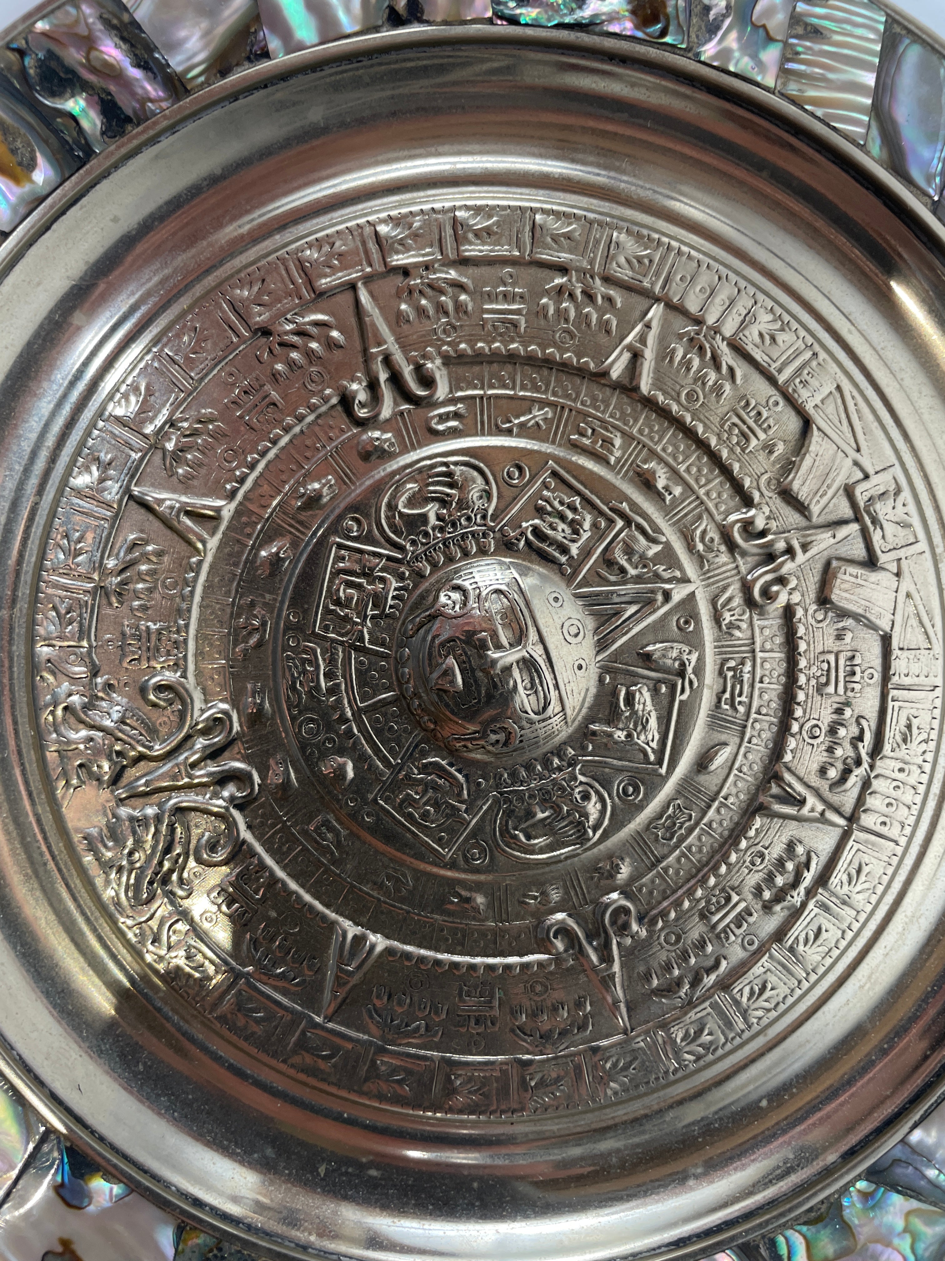 Close-up of a metallic object with intricate designs and symbols