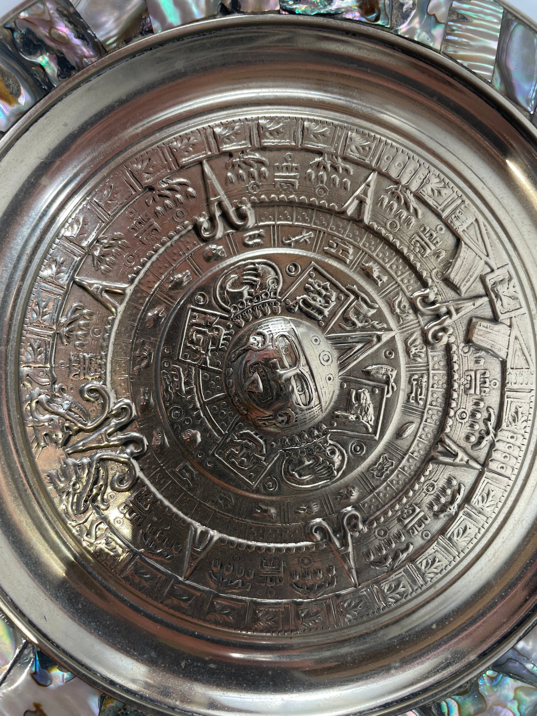 Close-up of a metallic object with intricate designs and symbols