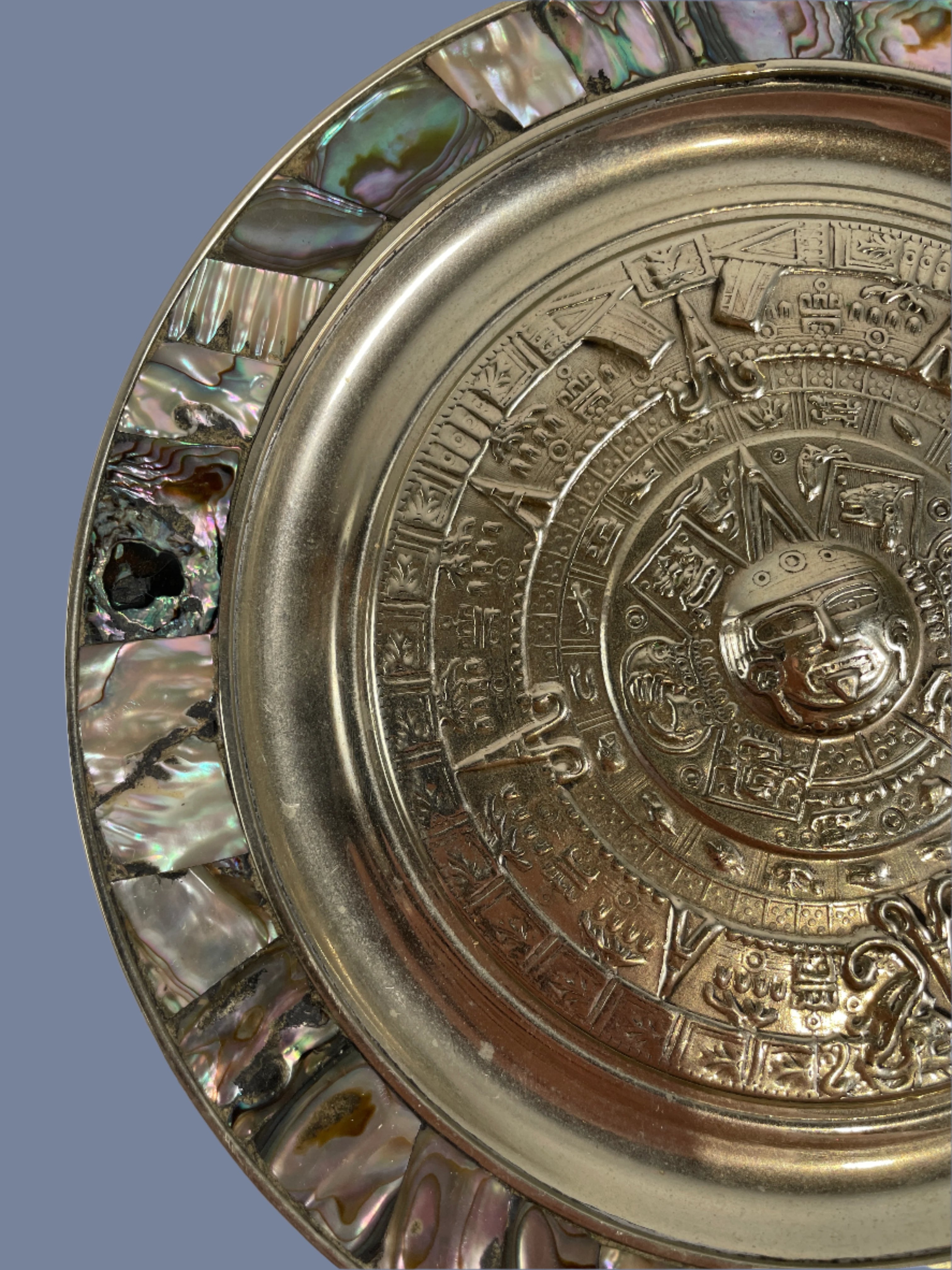 Decorative plate with intricate designs and shell inlay on a white background