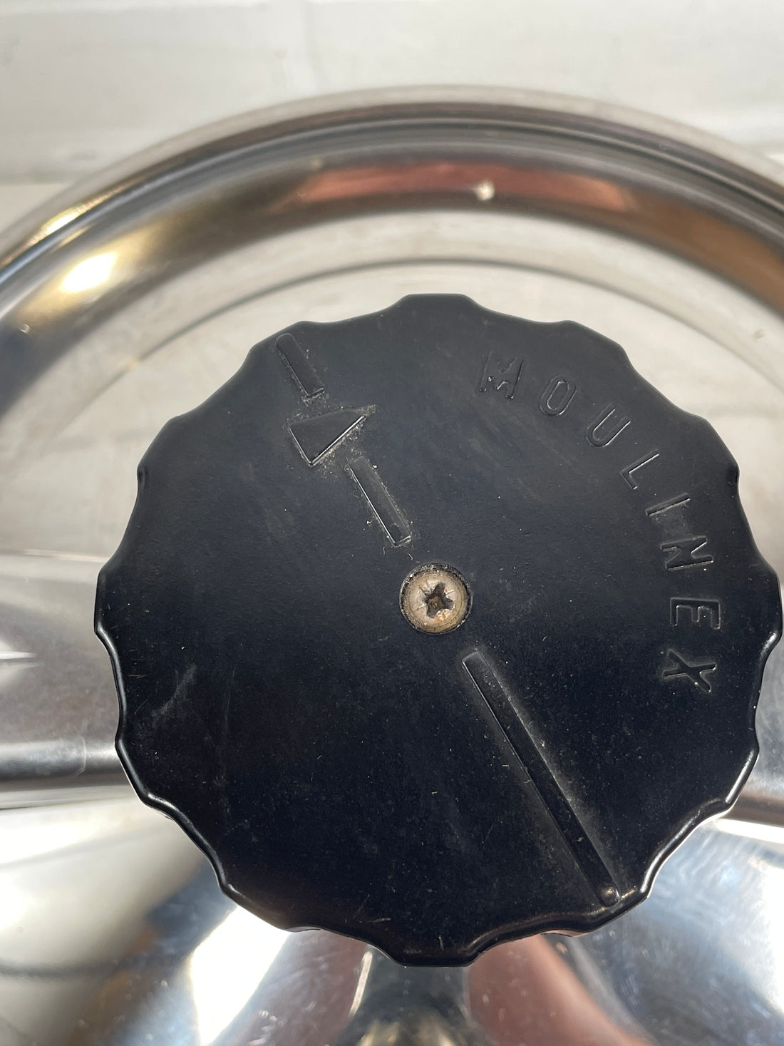 Black lid knob with 'Mullinex' branding on a metallic surface