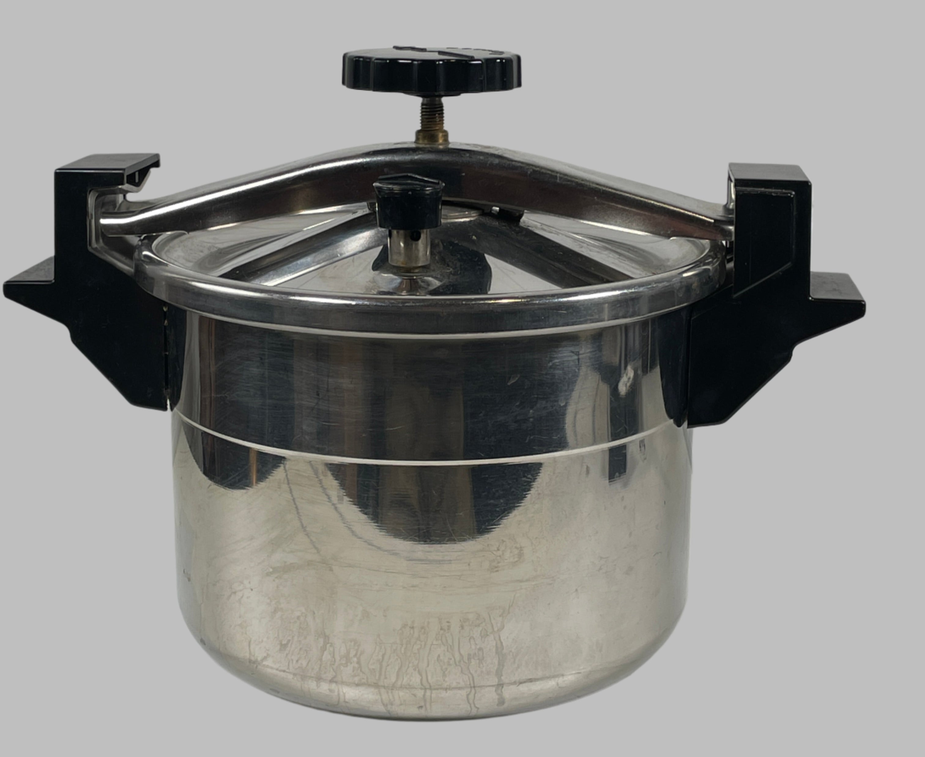 Metallic cylindrical object with a black top on a textured white background