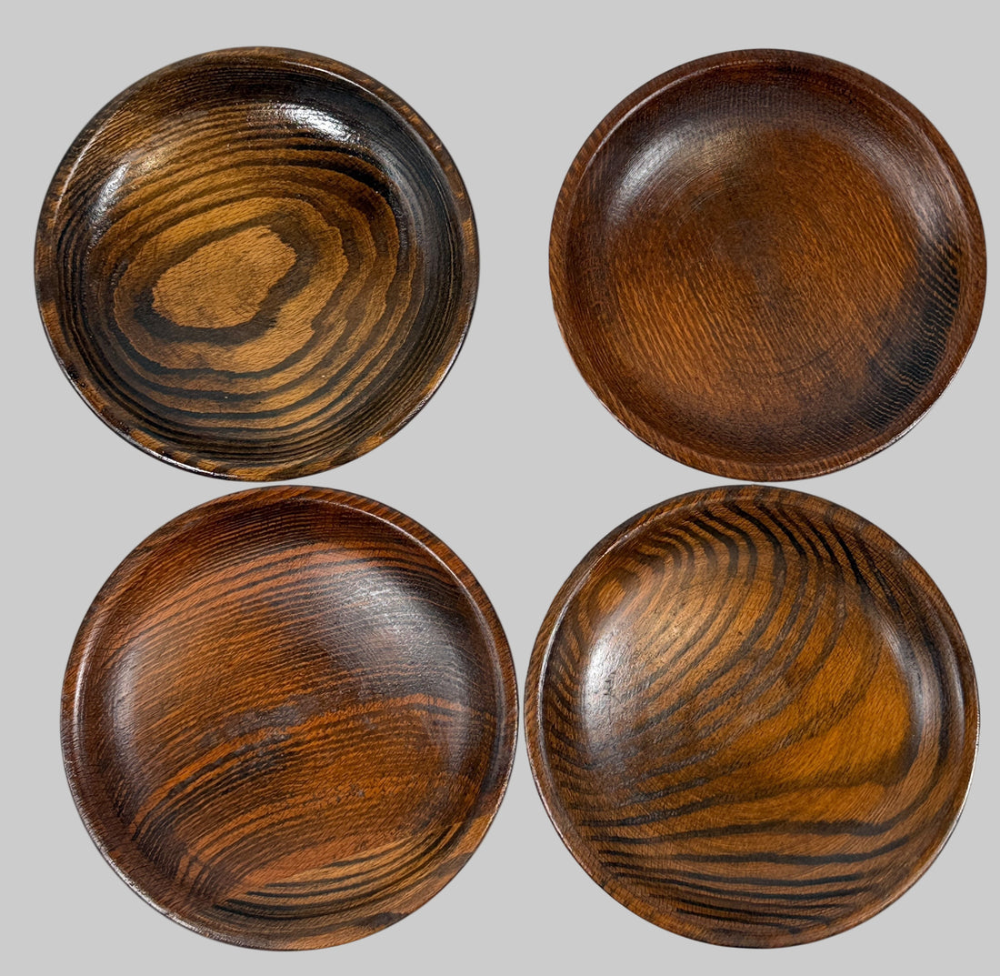 Four wooden bowls with a dark brown finish on a white background