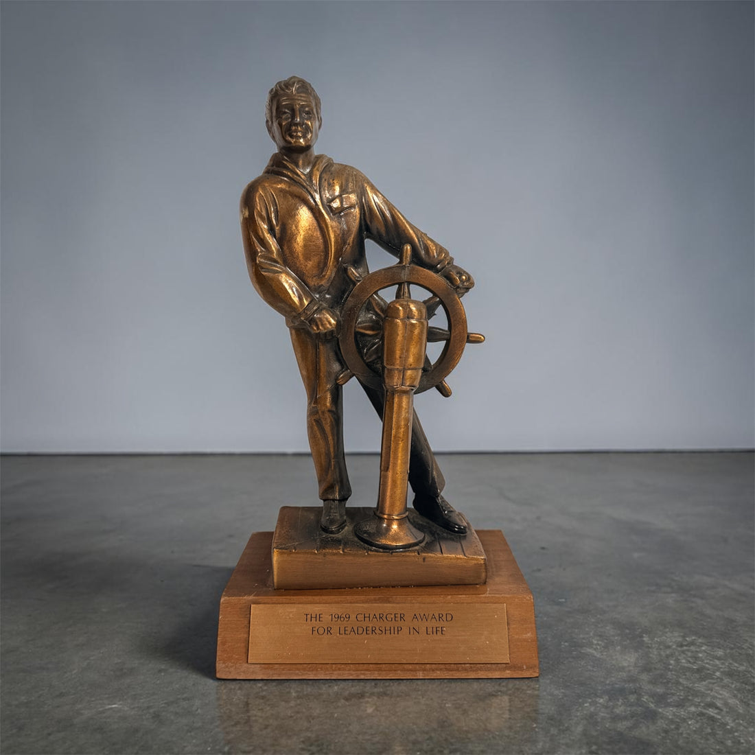 Vintage 1969 sailor helm award statue with bronze finish on wood base. Nautical décor piece with plaque, ideal for maritime collectors or mid-century display