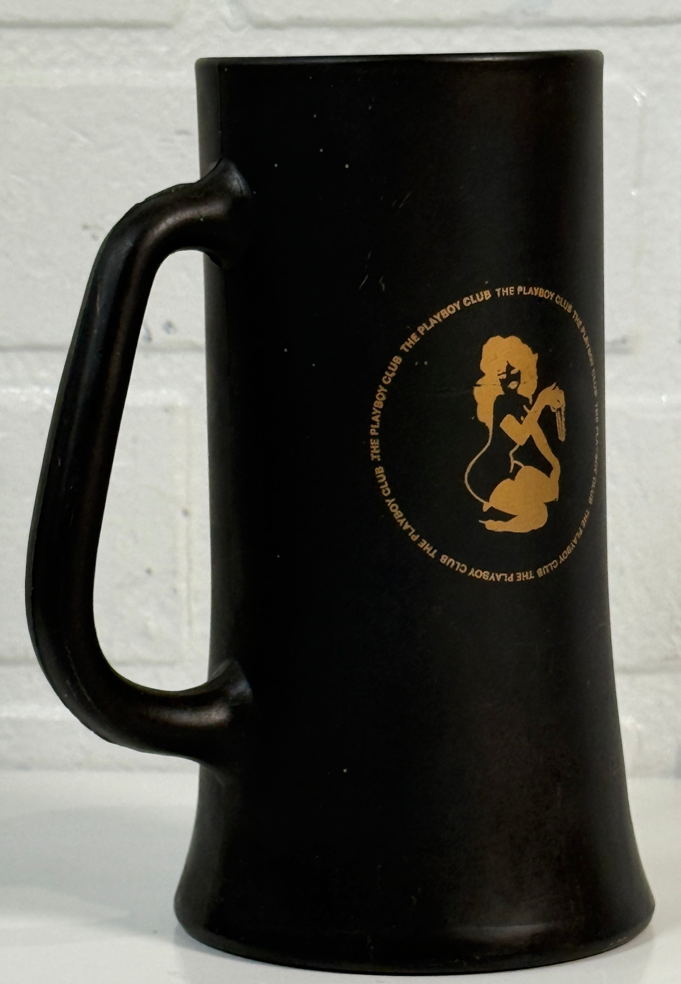 Black mug with gold logo on a light gray background
