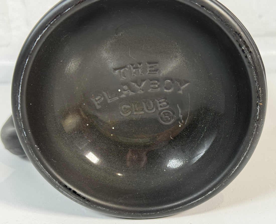 Black plastic component with 'The Playboy Club' branding on a white background