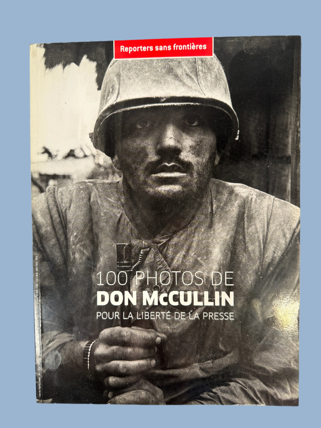 Book cover with black and white photo of a person wearing a helmet and jacket, featuring text about Don McCullin's photographs.