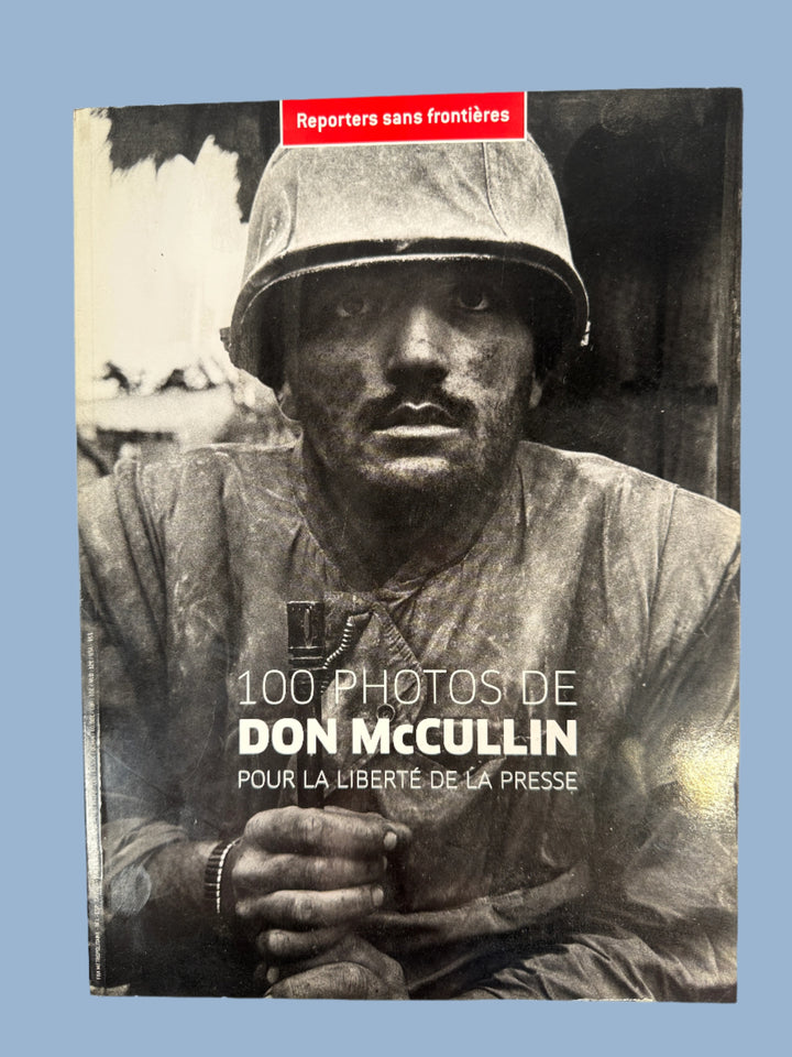 Book cover with black and white photo of a person wearing a helmet and jacket, featuring text about Don McCullin's photographs.