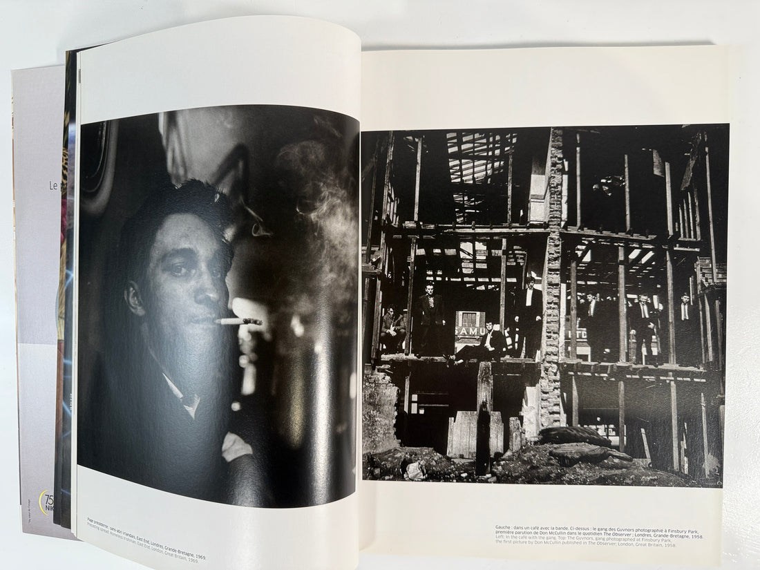 Open book showing black and white photographs of a person and a dilapidated building.