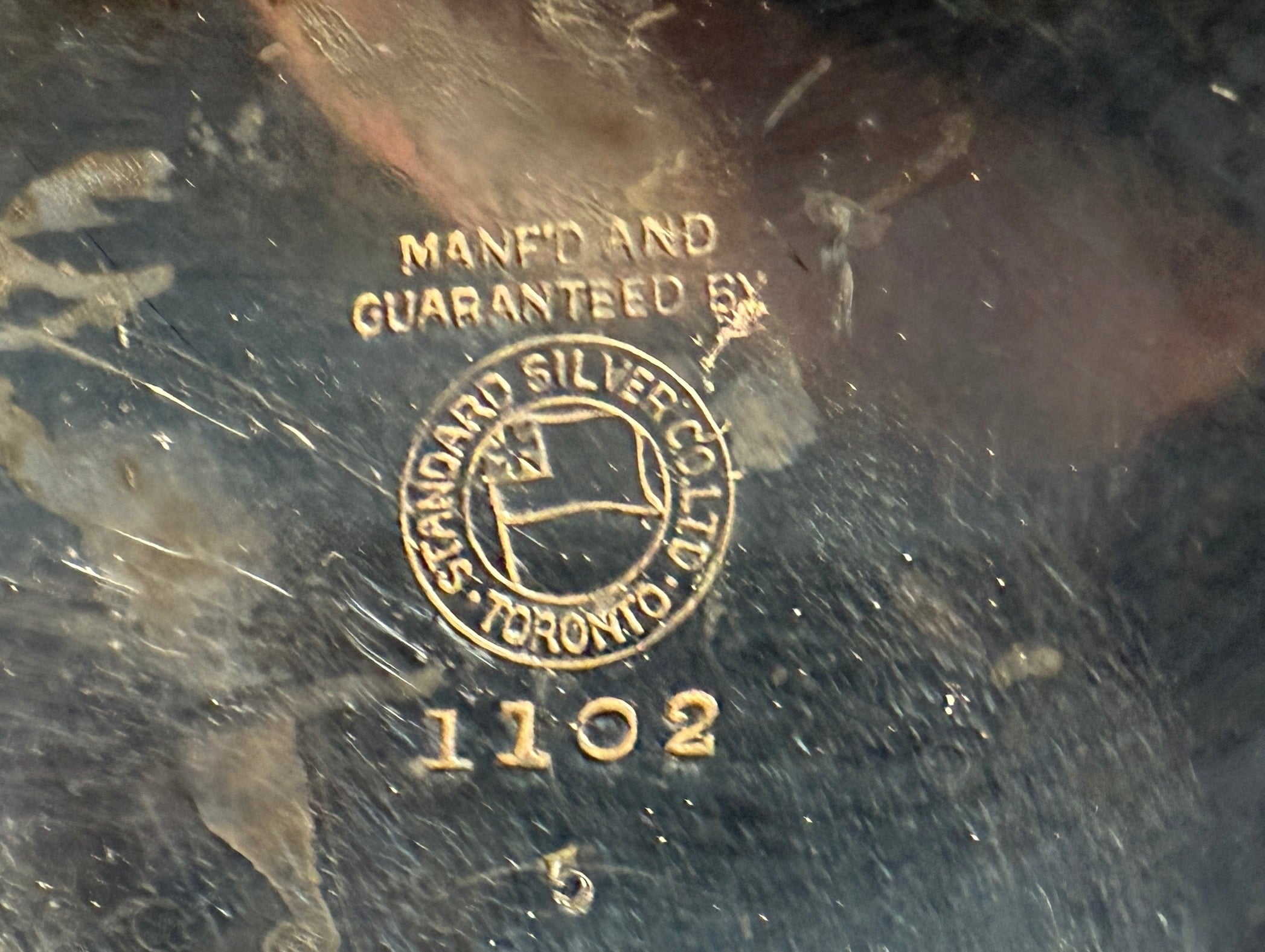 Close-up of a silver hallmark with 'Standard Silver Co.' branding on a dark background.
