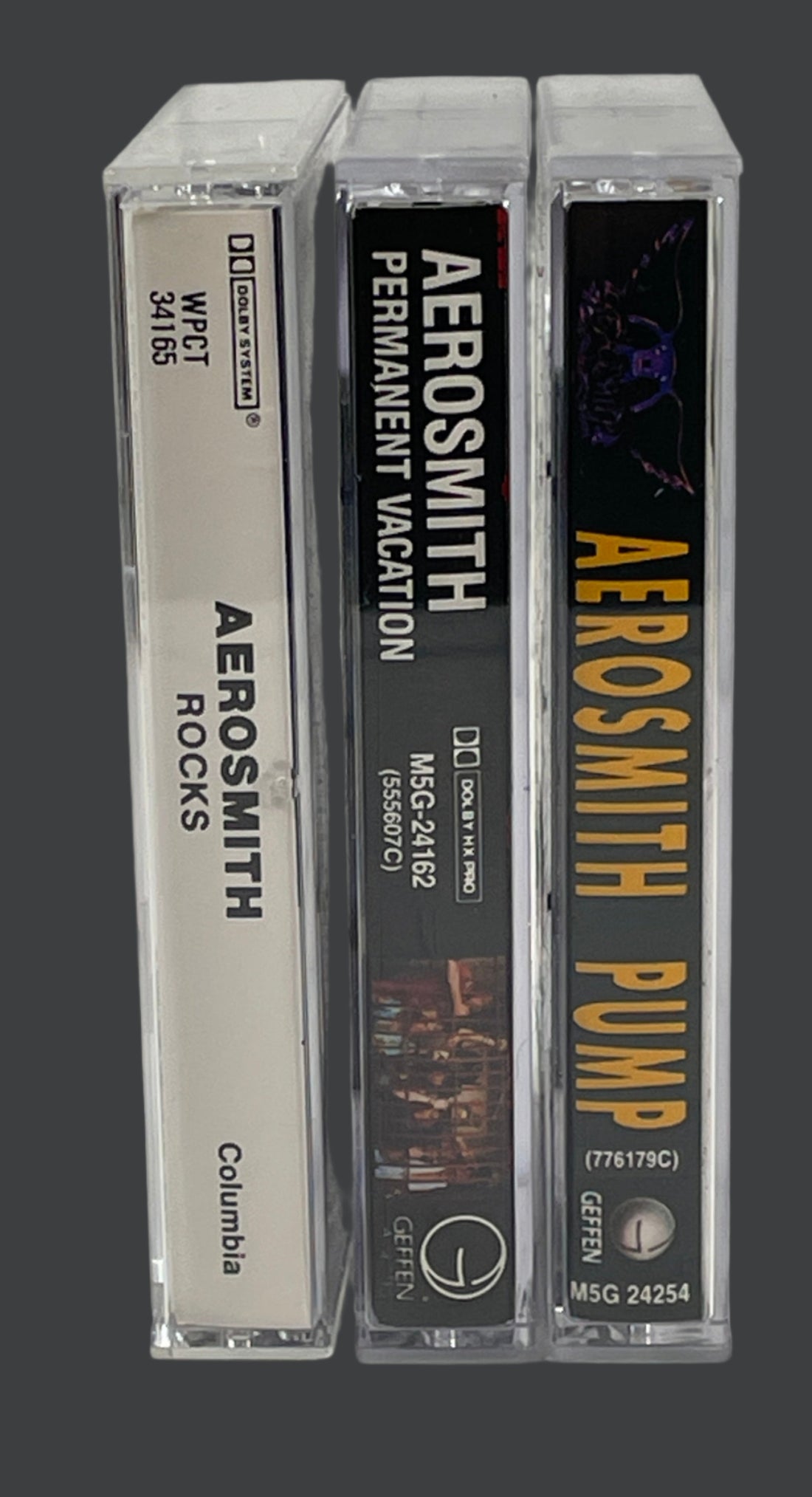 Three Aerosmith cassette tapes stacked on a textured white background