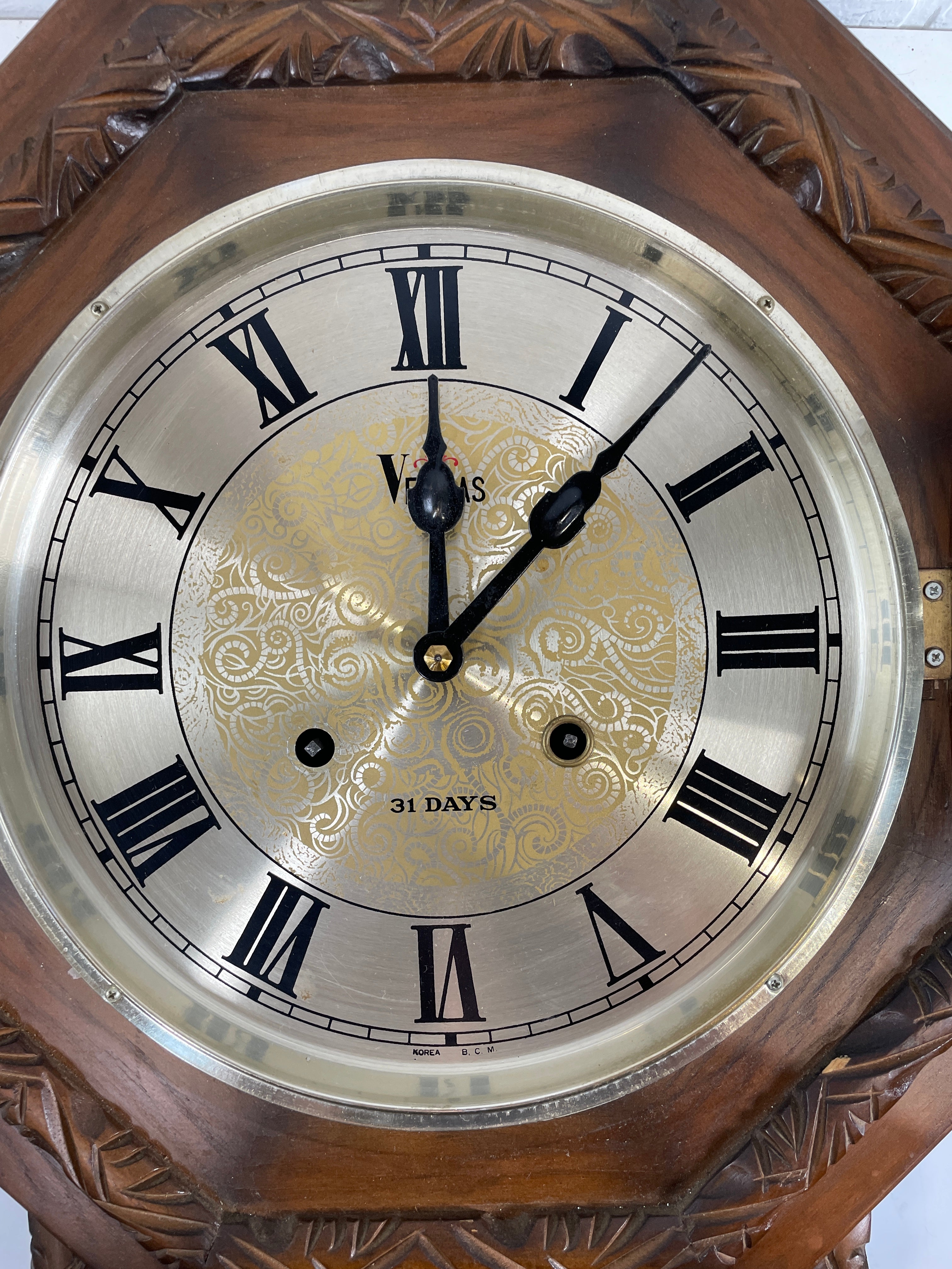 Close-up of a decorative clock with Roman numerals and intricate design.