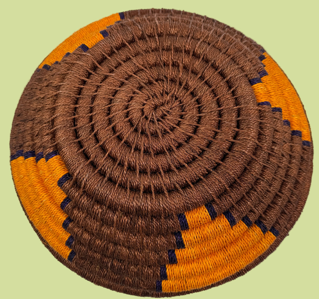 Round woven mat with brown and orange spiral pattern on a white background