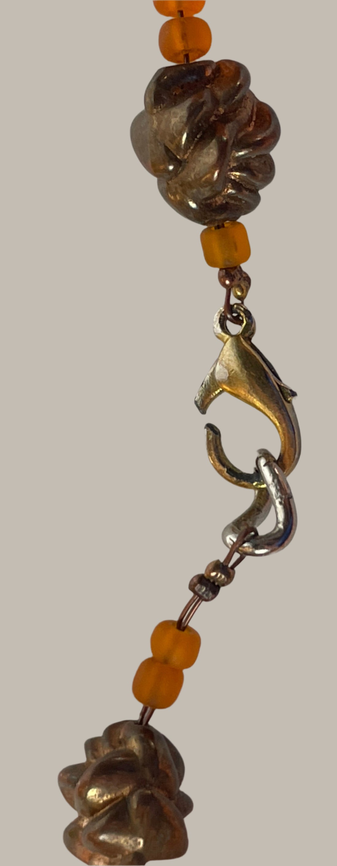 Close-up of a beaded necklace with a clasp on a light gray background