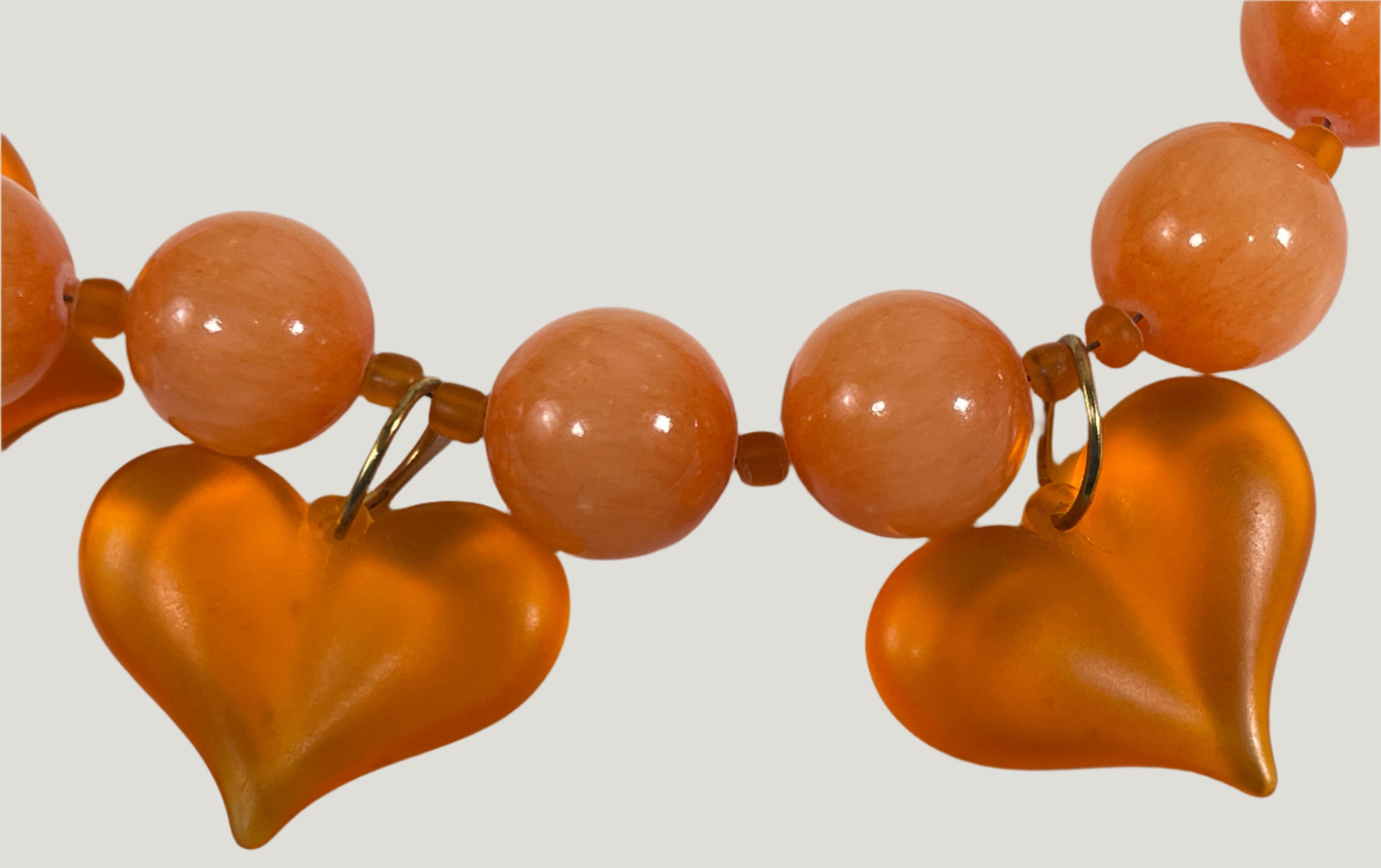 Necklace with orange heart-shaped beads on a white background