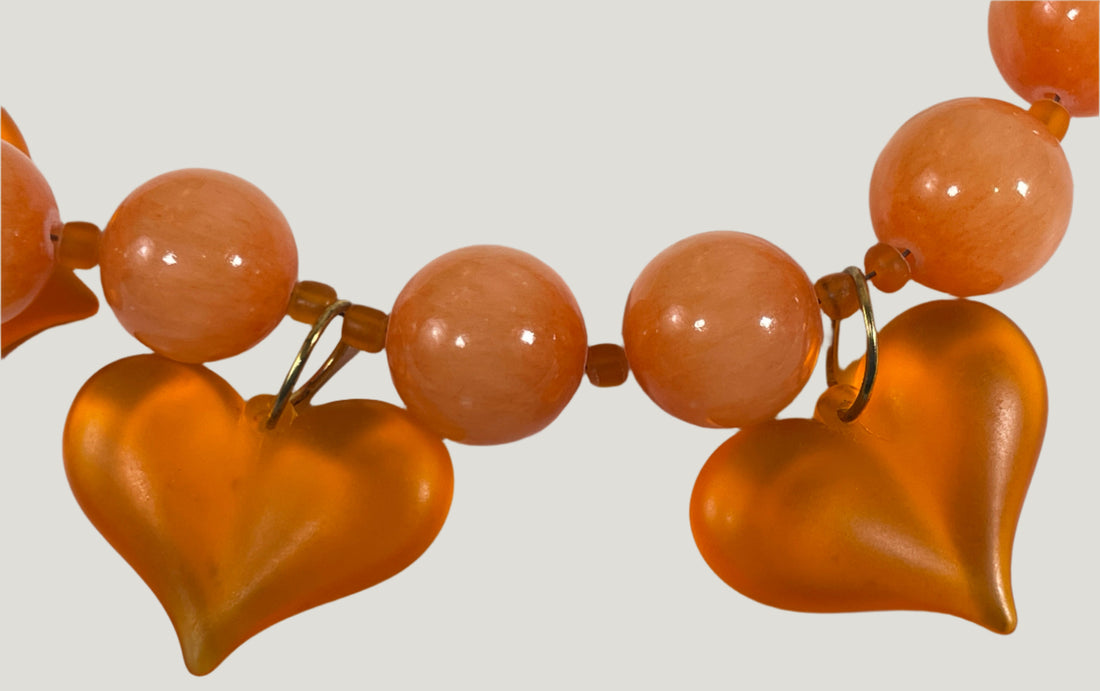 Necklace with orange heart-shaped beads on a white background