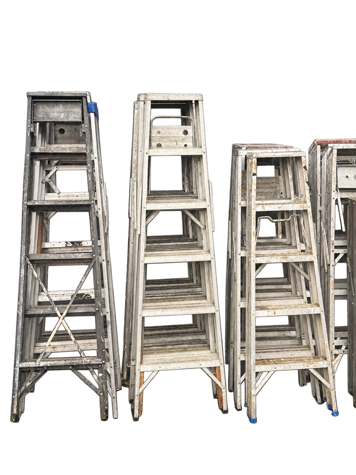Used aluminum stepladders with visible paint marks and wear, background removed