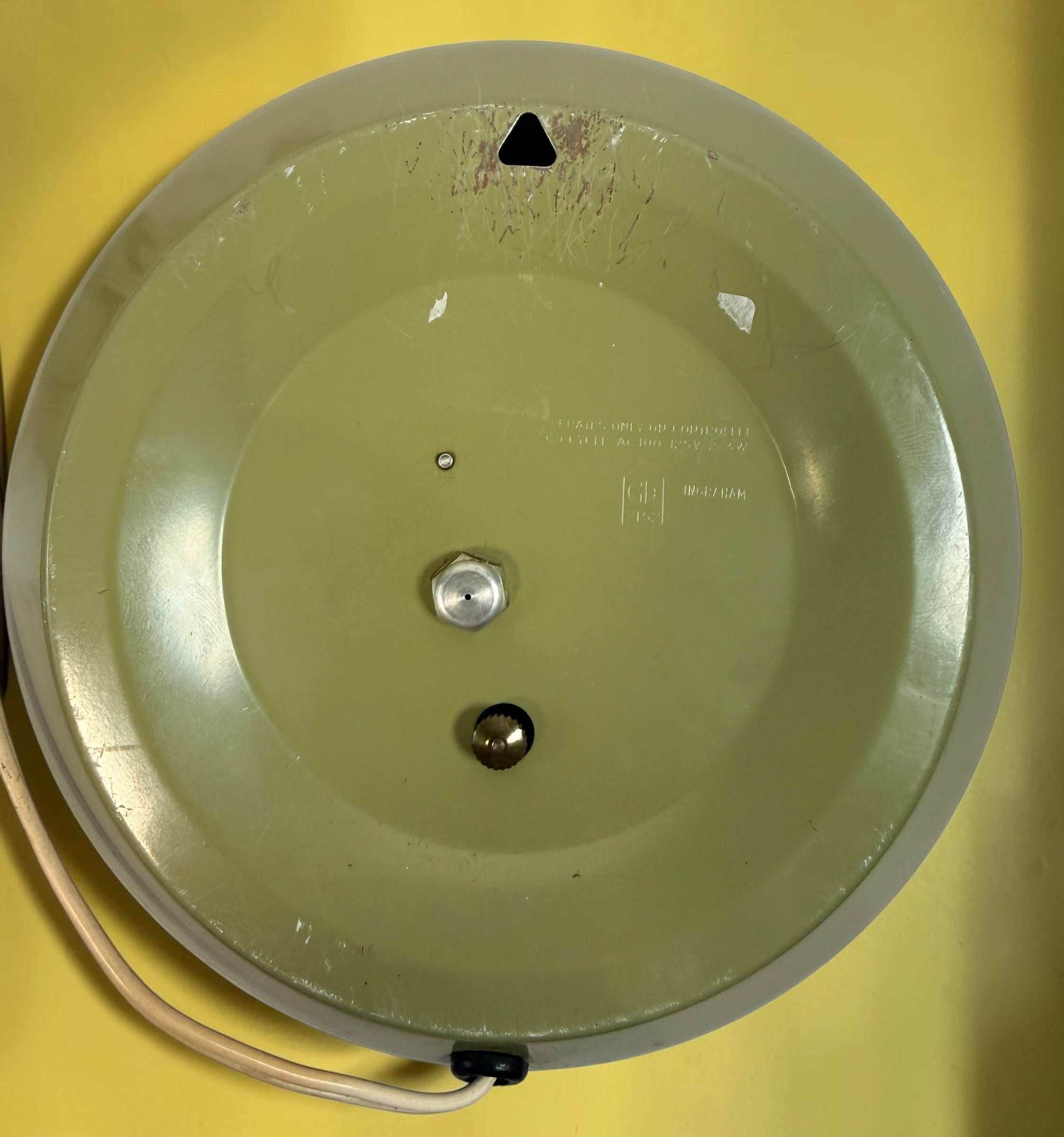 Back view of an Éco-Dépôt Montréal vintage Ingraham electric wall clock with a sage green casing and power cord.