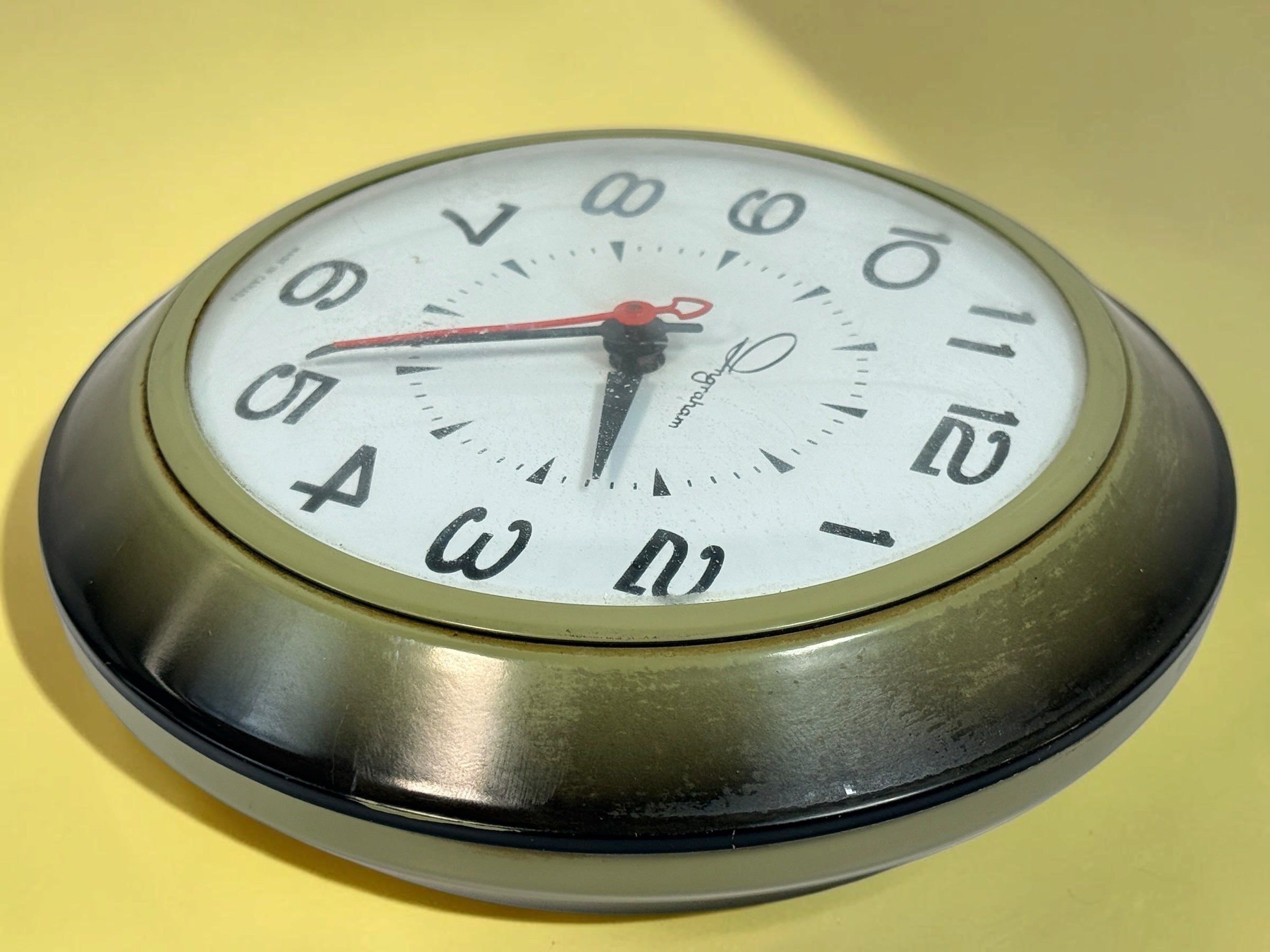 Éco-Dépôt Montréal vintage Ingraham electric wall clock with a rounded metallic frame, white face, and red second hand.