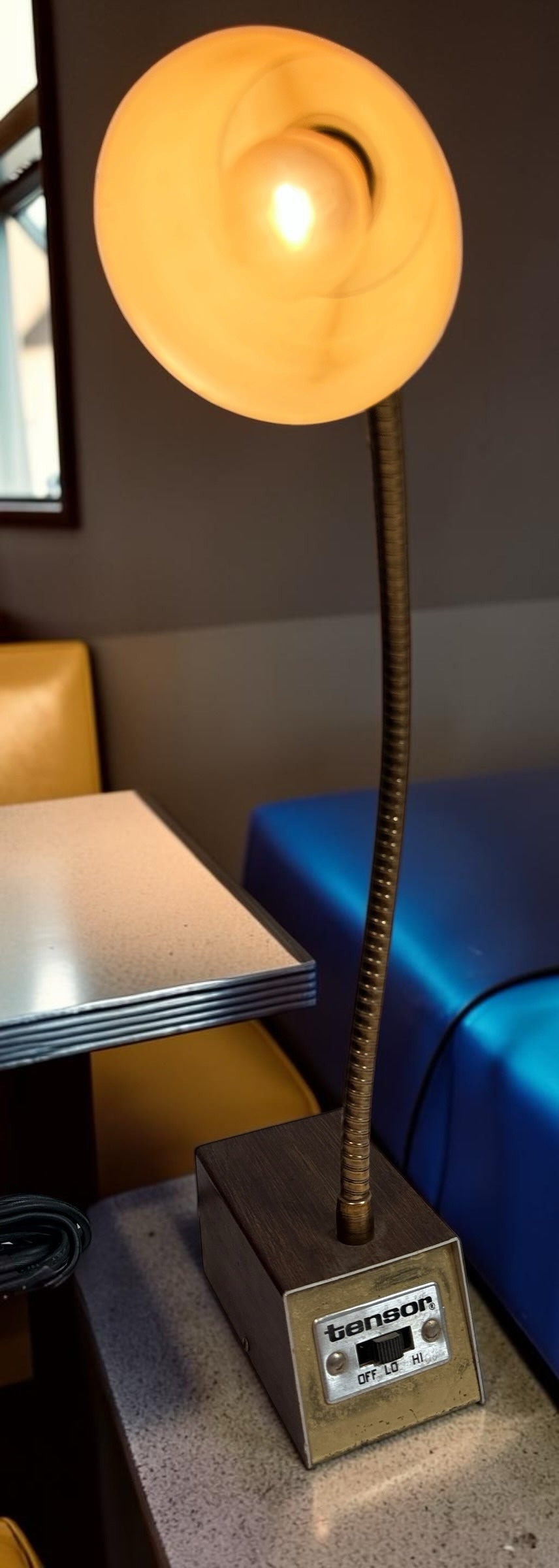 Éco-Dépôt Montréal vintage Tensor desk lamp with a flexible gooseneck, wood-grain base, and warm glowing light.