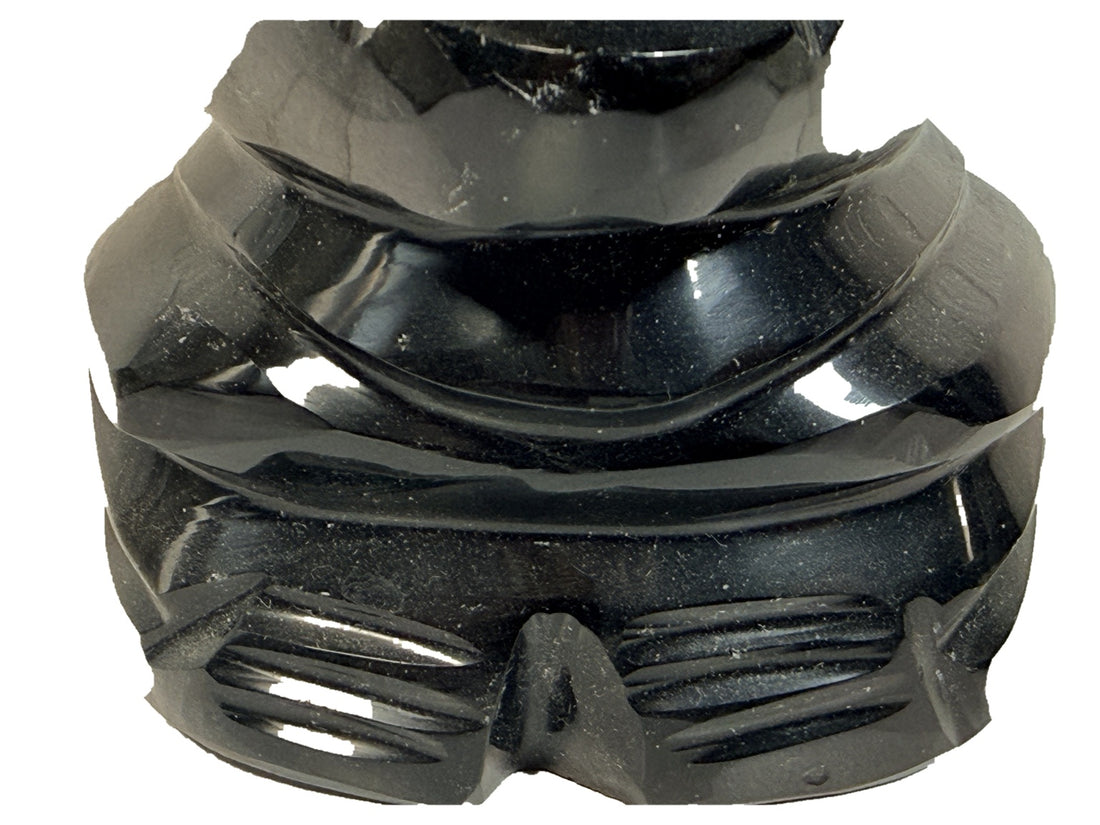 Détail de la base sculptée du buste en onyx noir sur fond blanc