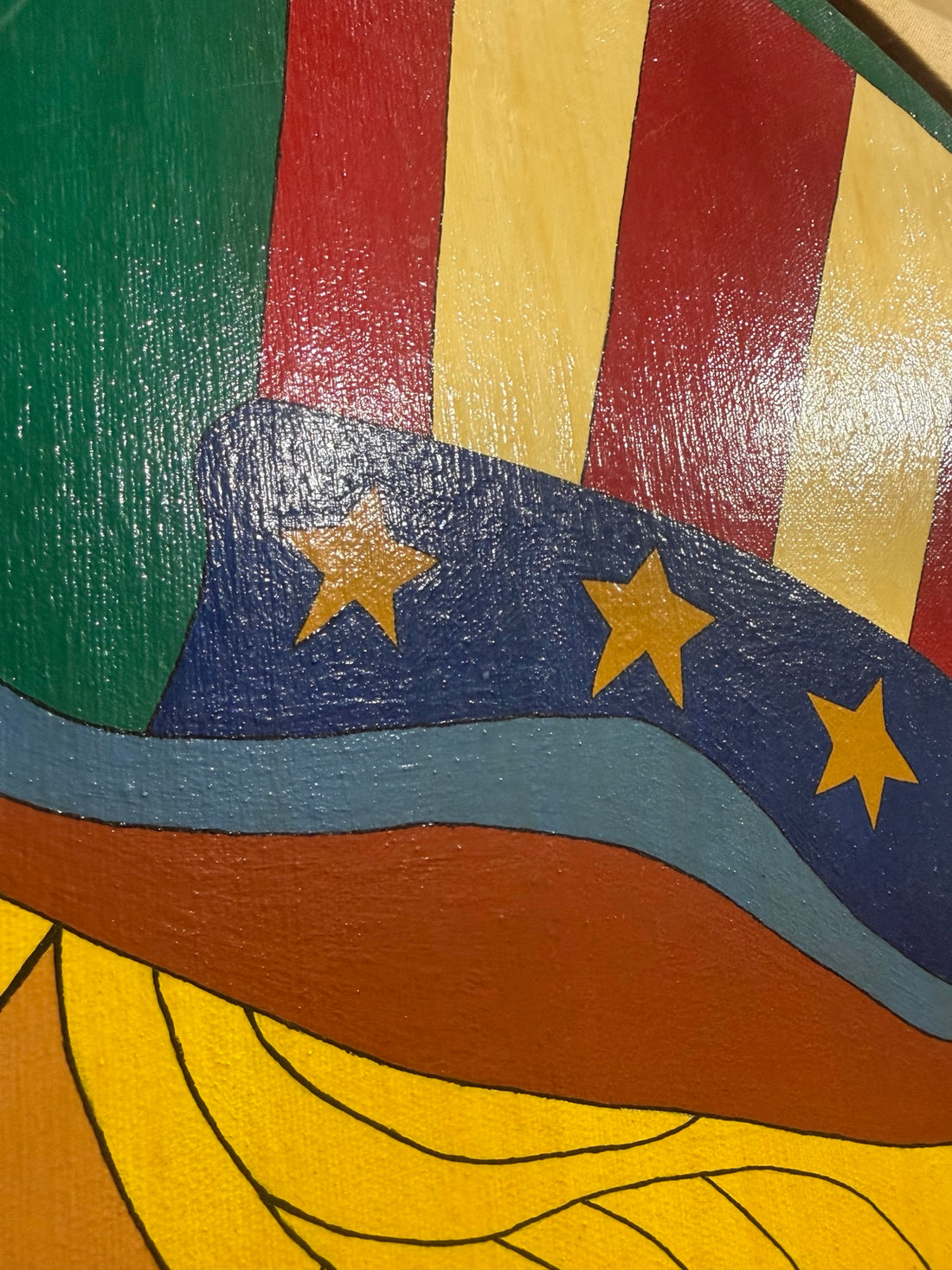 Close-up of painted canvas texture on Uncle Sam's red, cream and blue hat.